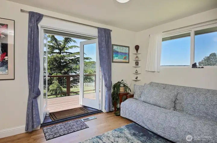 Main level primary bedroom with 1/2 bath and french doors leading to the deck.