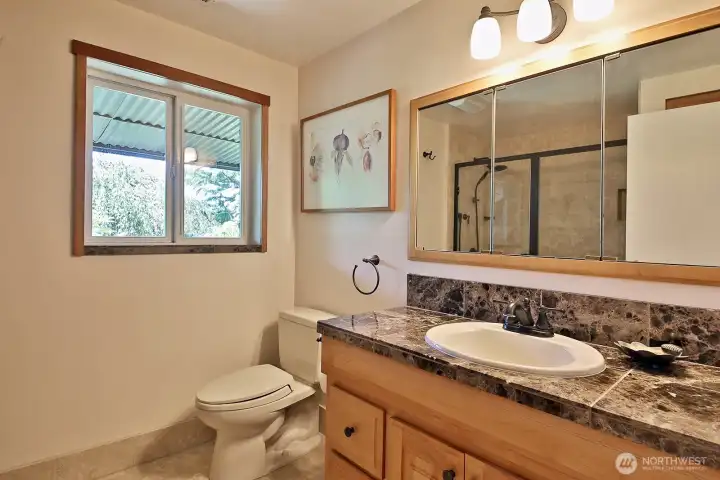3/4 bath with marble countertops serves the guest suite on the lower level.