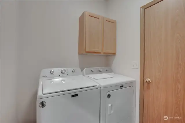 Laundry room with storage space, and easy access to garage. The washer and dryer remain with the property.