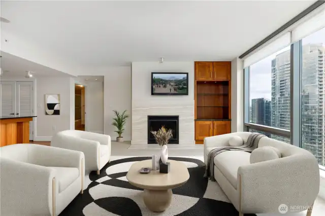 Living room features built-ins, fireplace set in stone surround and mounted television, with south-facing windows for great natural light. Virtually staged.