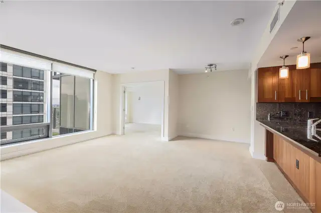 Living room with dining or study nook, and double door to primary suite.
