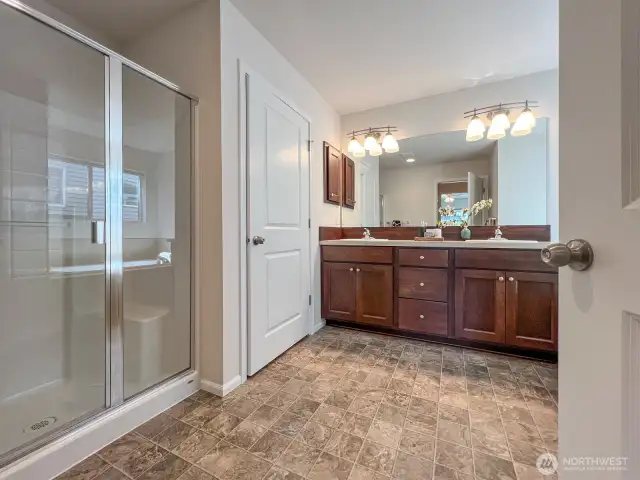 The 5-piece primary bath is in pristine condition with a large walk-in shower, private toilette, and large, jetted soaking tub flanking the 2 vanity sinks.