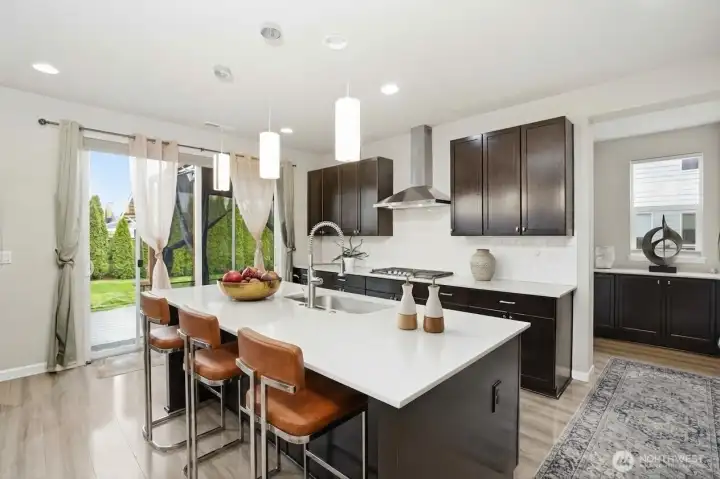 Stunning kitchen with HUGE island, gas range and tremendous storage. (digitally staged)