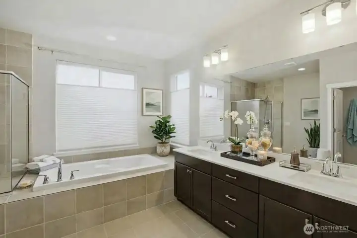 Primary Bathroom with separate shower, soaking tub, dual sinks, quartz countertops, and a huge walk in closet. (some items digitally staged)