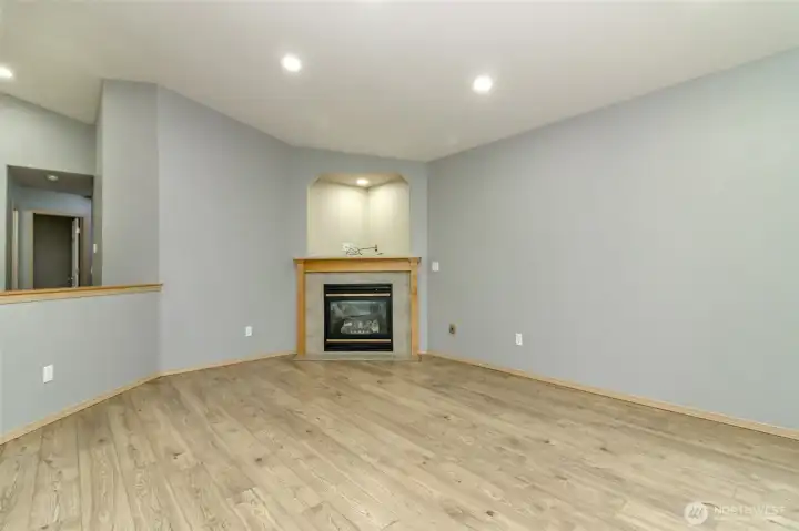 Livingroom with cozy gas fireplace, entertainment alcove, theatre lighting and Vinyl Plank Wood flooring