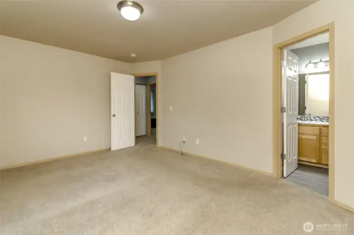 Primary bedroom with walk-in closet and 5-piece bathroom with large garden tub.