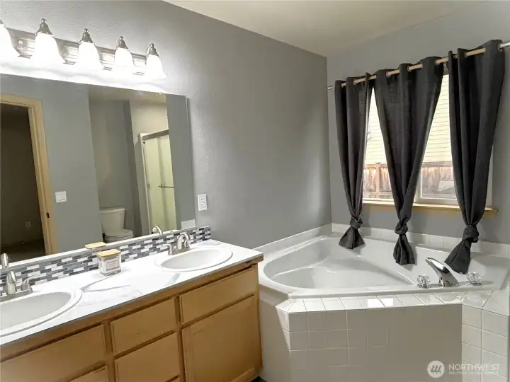 Primary bedroom's bathroom with large garden tub & separate  shower.