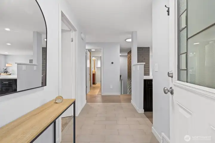 Bright interior entry foyer with tile flooring, clean modern finishes, and an open flow into the main living spaces.