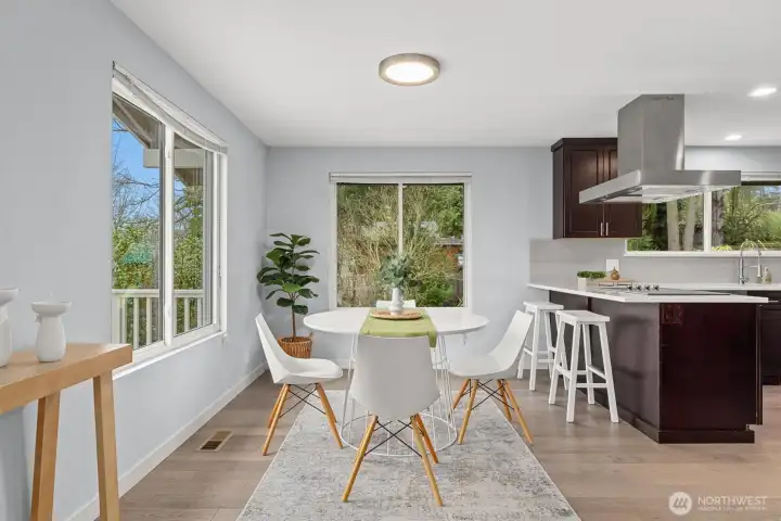Dining area with oversized windows, peaceful neighborhood outlook, and open layout adjacent to the chef-inspired kitchen.