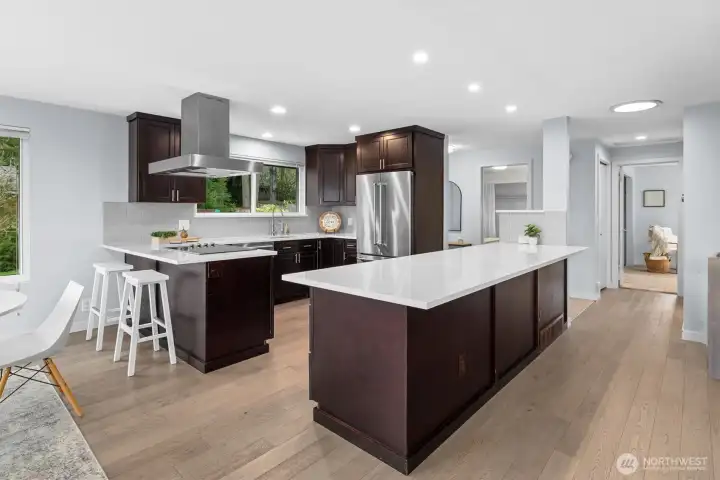 Updated kitchen with oversized quartz island, stainless steel appliances, and abundant cabinetry, designed for everyday living and hosting.
