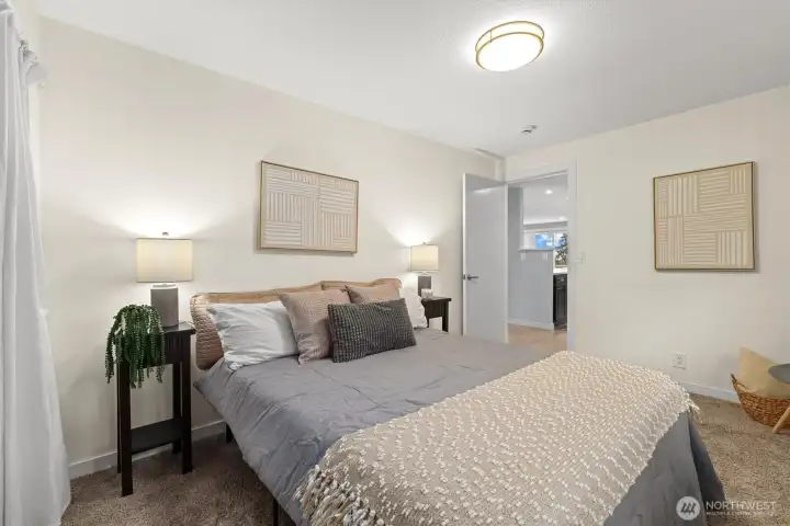 Secondary bedroom with plush carpet, bright walls, and private, peaceful outlook.