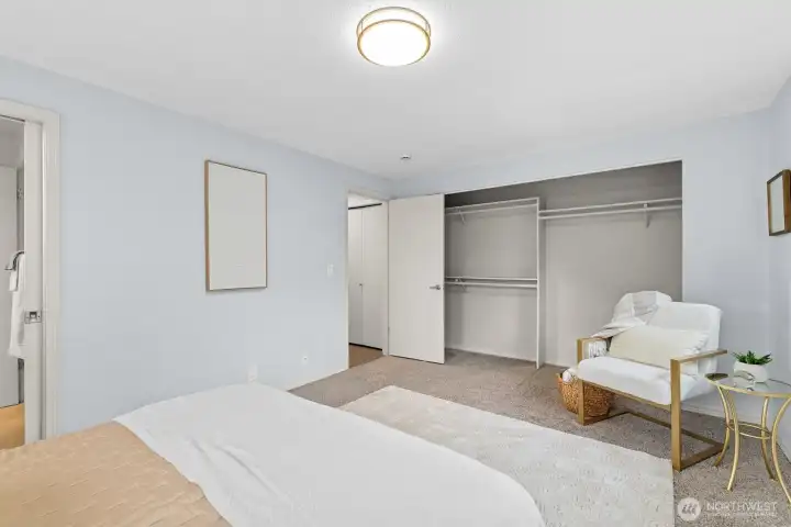 Primary bedroom with generous floor space, soft carpet, and convenient access to the ensuite bath.