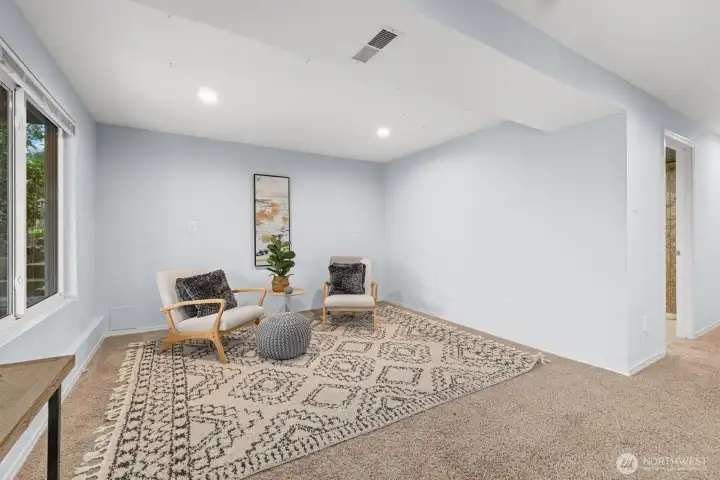 Lower-level bonus living space with oversized windows and versatile layout for lounge, office, or hobby use.