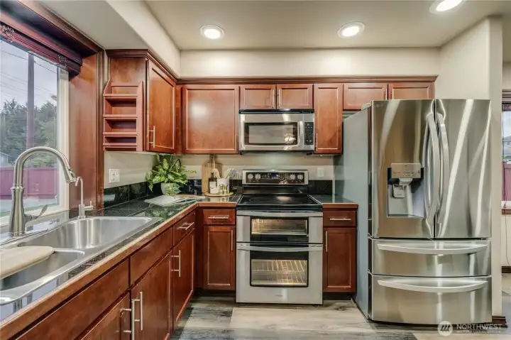 This kitchen is giving Dark & Luxurious vibes!. Gleaming Updated Stainless Appliances Stay!