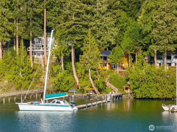 Classic PNW setting. Perfectly perched home with easy access to the shore and deep-water dock that can accommodate a 45'-50' boat!