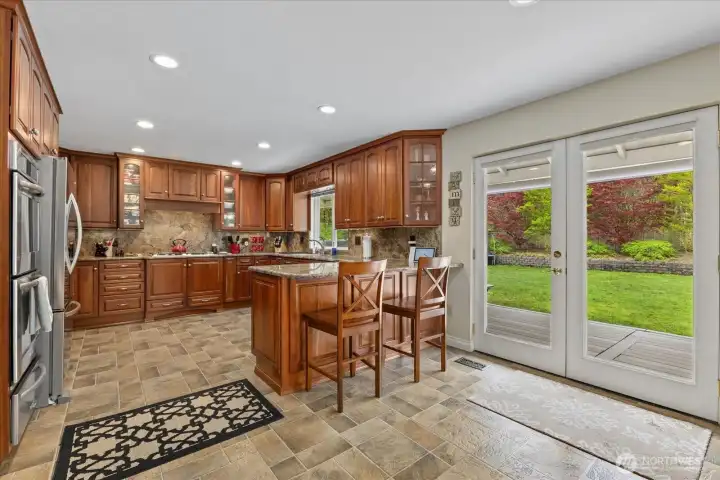 Chef-inspired kitchen featuring double ovens, gas cooktop, warming drawer & custom cabinets w/lighting