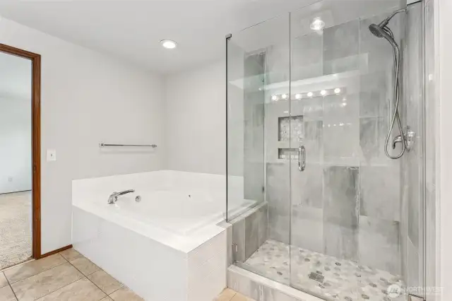 Spa-like primary bath with soaking tub and separate shower.