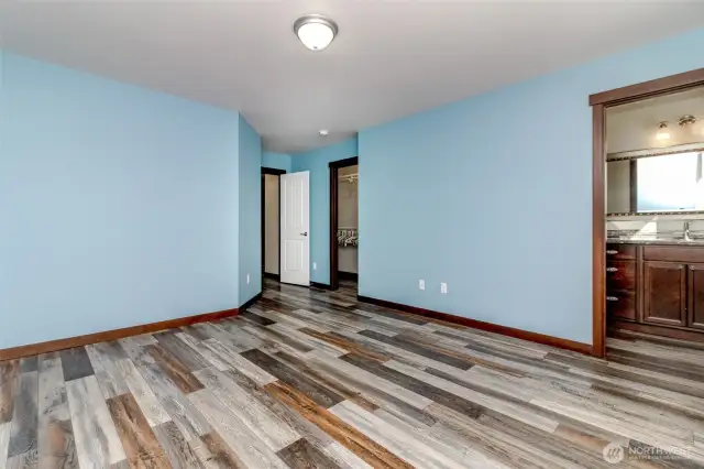 Primary with walk in closet, large 3/4 bath, and luxury plank flooring.
