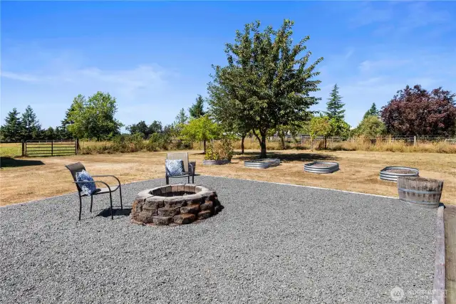 Backyard firepit, fruit trees, and raised garden beds