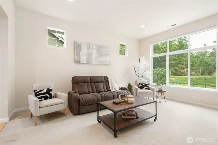 This living room has large picture windows looking out to a beautiful greenbelt.