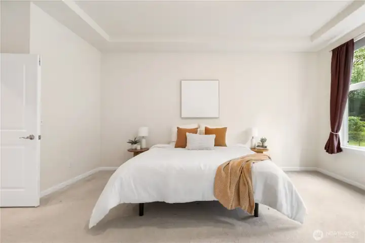 Main level primary suite is large and bright and hosts a spacious closet and en-suite.