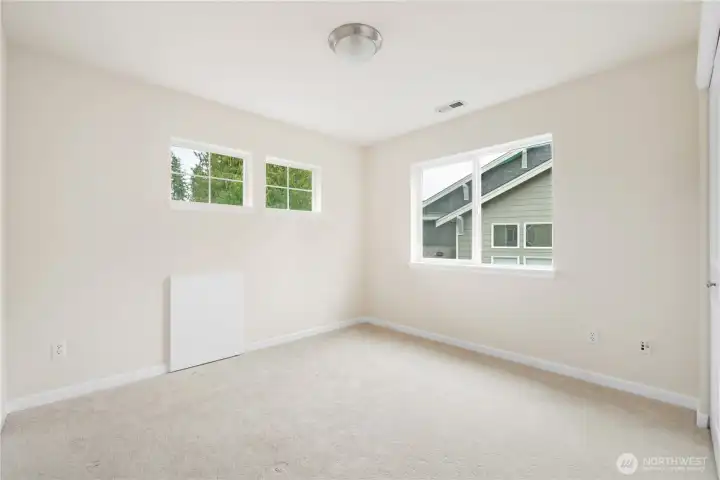 Upstairs bedroom boasts tons of natural light. *Attic access door for additional storage if desired.