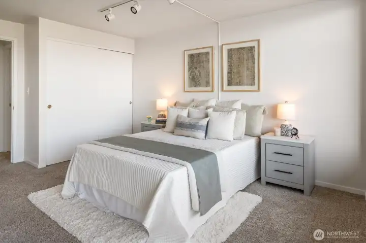 Well designed, the bedroom offers a wall of closets on one side and banks of windows on the other.