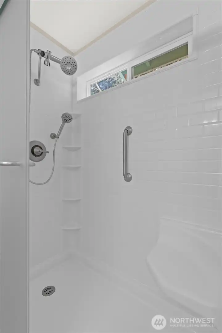 Unwind in the spacious shower featuring a sleek, new shower head for a refreshing experience