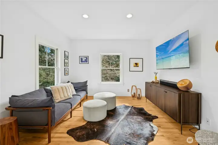 Just off the kitchen and dining area, this versatile bonus room offers a bright, comfortable retreat with clean modern finishes and peaceful wooded views. Ideal as a media lounge, office, or den, it provides flexible space to unwind while staying connected to the heart of the home.