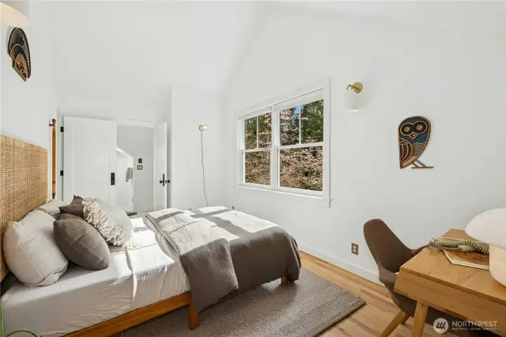 This upstairs bedroom is light and airy with vaulted ceilings, wide-plank floors, and peaceful treetop views. Recently enhanced with its own private bathroom, it’s an ideal guest suite or comfortable secondary bedroom with added privacy.