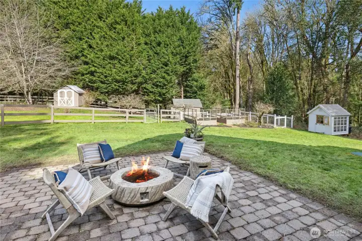 Just off the patio, a charming fire pit gathering area invites evenings under the stars with views across the lawn and gardens. The outlook extends to the main paddock and goat pen, perfectly capturing the relaxed, rural-luxury lifestyle this property offers.