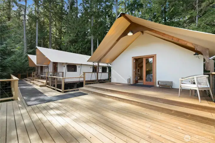 Three Rainier Safari tent accommodations, also known at the "Glamping Nests"  sit on an expansive deck, each paired with its own bathroom and individual heat for comfortable all season use. These non-permanent dwellings create a unique retreat setting with elevated views overlooking the property. Ideal for hosting, creative escapes, or endless retrest possibilities.