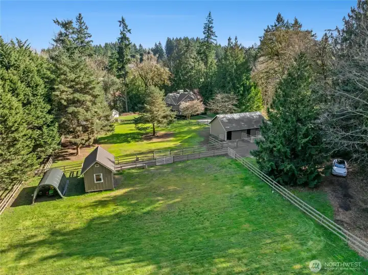 This aerial view highlights the property’s thoughtful layout between the barn and the safari-style Nests, with fenced pastures and open, usable acreage. A second gated entrance provides convenient RV parking and includes an EV charger, adding flexibility for guests, trailers, and modern lifestyle needs.