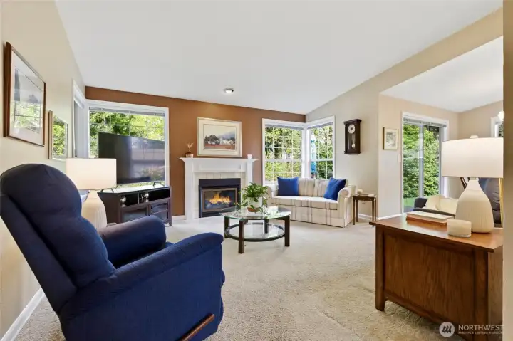 Upon entry, a spacious living room with a cozy fireplace flows seamlessly to the dining room and out to a private patio and side yard—ideal for outdoor dining, gardening, or quiet evenings.