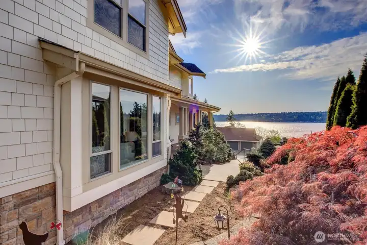 This space does more than just connect-it welcomes you in. A gently designed path leads you to the front door, surrounded by thoughtful landscaping, soft light, and glimpses of the water beyond. It’s an approach that feels calm, intentional, and quietly beautiful—setting the tone before you even step inside.