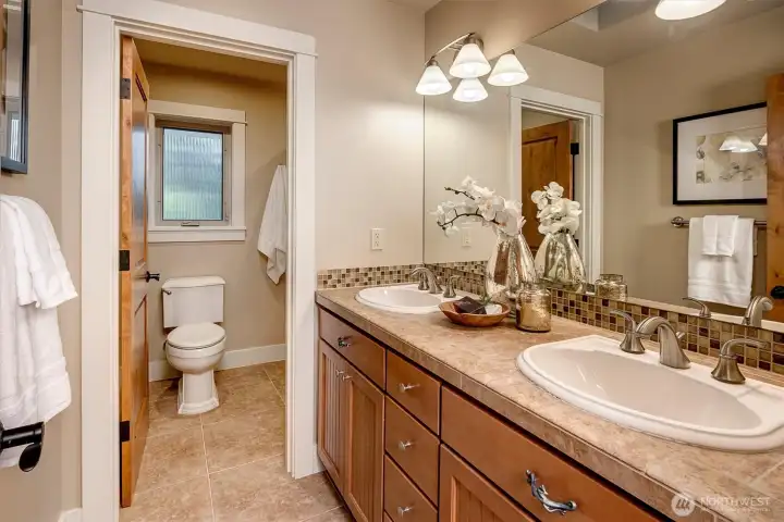 Clean, functional, and thoughtfully finished, the main bath offers a double vanity with ample storage.