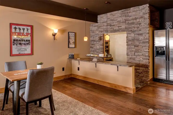 Thoughtfully designed for hosting, the built-in bar with stone accents and seating creates a natural gathering point. With space for drinks, snacks, and easy serving, it turns movie nights and game days into a full experience.
