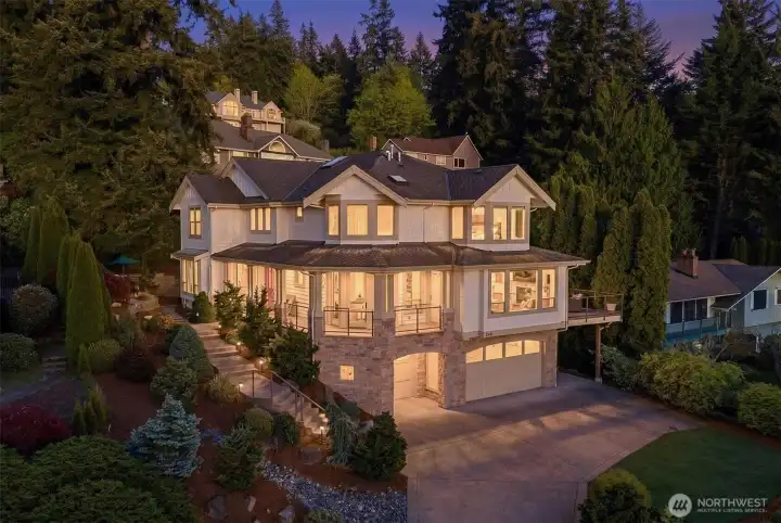 A striking first impression with timeless Northwest architecture, this home blends natural stone and crisp siding, all beautifully illuminated at dusk.