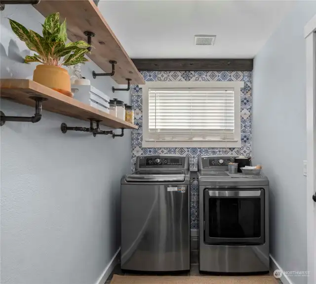 Designer laundry room with exposed wood beams, custom shelving and tile accent wall for the perfect pop of color.