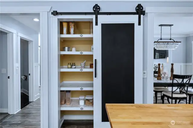 The custom designed pantry is an efficient and useful space complete with designer details! From the chalkboard barn door, custom built shelving and venetian plaster finished back wall - its a beautiful addition to this kitchen.