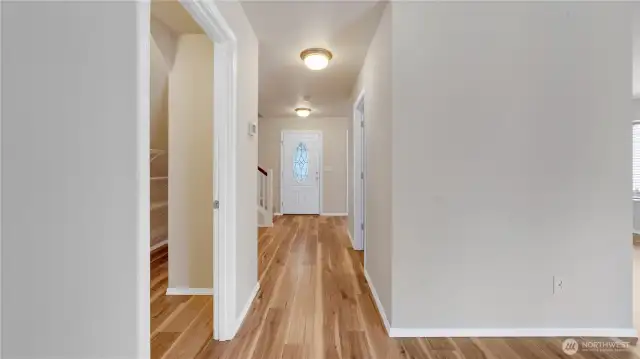 View through the hallway to the front door. Pantry and entry to garage is on the left