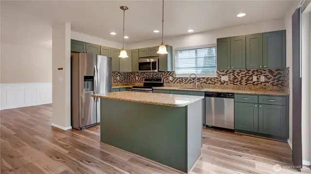 Kitchen with island, granite counters and tile backsplash
