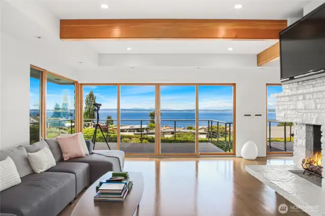The open floor plan living area with gleaming hardwood floors and a gas burning fireplace.