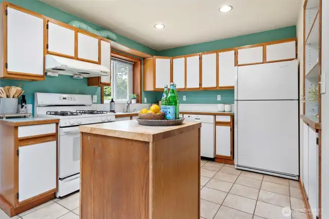 Kitchen has great storage space and a portable island for extra countertop