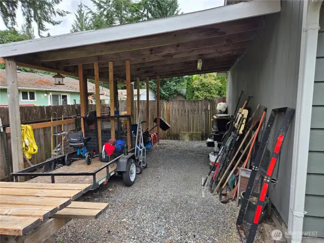 This carport leads to the backyard. Toys or cars fit here for additional covered space.