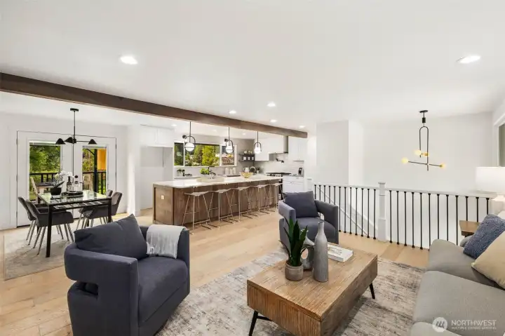 The open-concept living, dining, and kitchen flow seamlessly together, highlighted by a striking wood ceiling beam and modern black railings that extend down both staircases and mirror the exterior design. A statement chandelier at the entry ties in beautifully, creating a cohesive and sophisticated, style throughout this inviting great room.