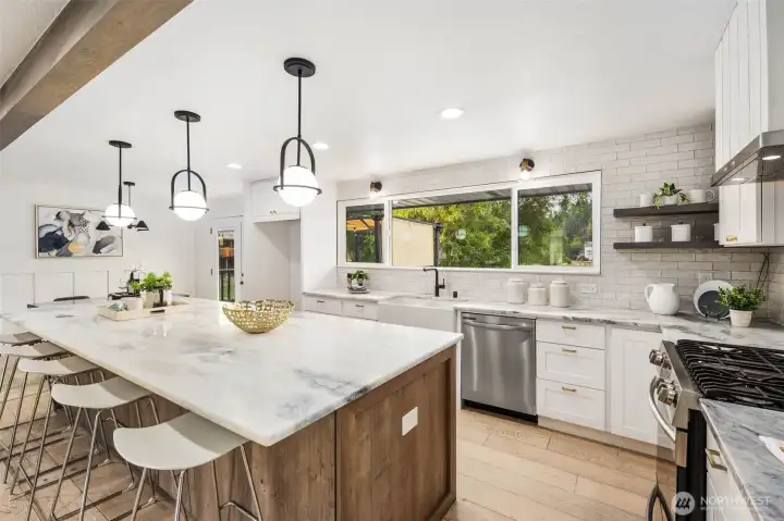 A chef’s kitchen anchored by a Frigidaire Gallery gas range with five burners and a full gas oven, paired with a premium Cavaliere range hood and convenient pot filler above. Stainless steel Samsung dishwasher completes the suite, combining performance and style.