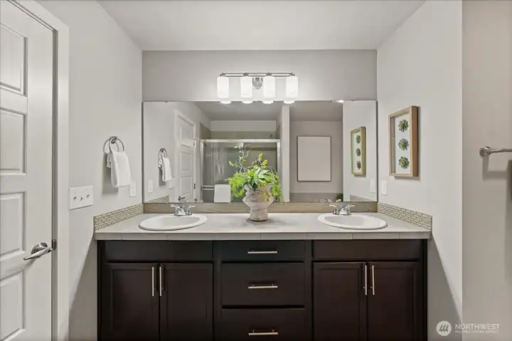 Spacious primary bathroom featuring dual sinks, abundant counter space, and a bright, open layout.