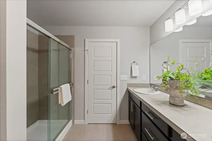 Spacious upstairs bathroom with large walk in shower, plenty of counter space and a functional layout to serve secondary bedrooms.