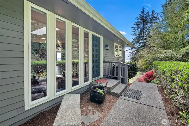 The walkway leading to the front door. Enjoy big windows that welcome in the natural lighting all around this home.